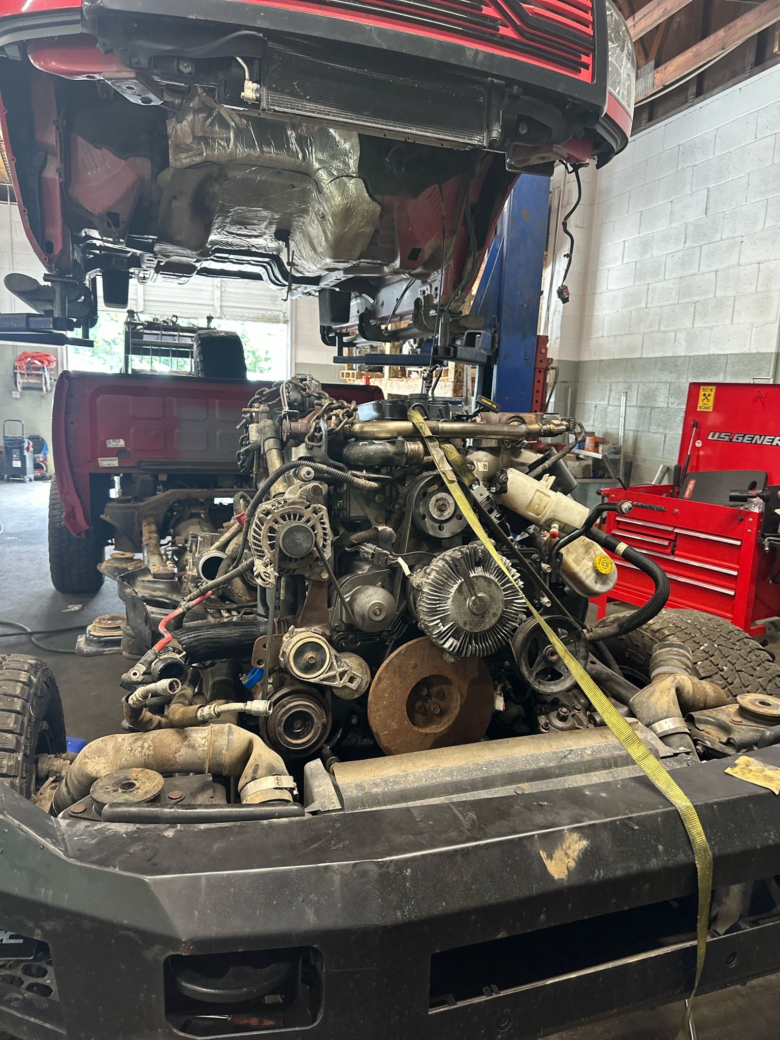 Truck engine pulled and sitting in front of the lift in our bay