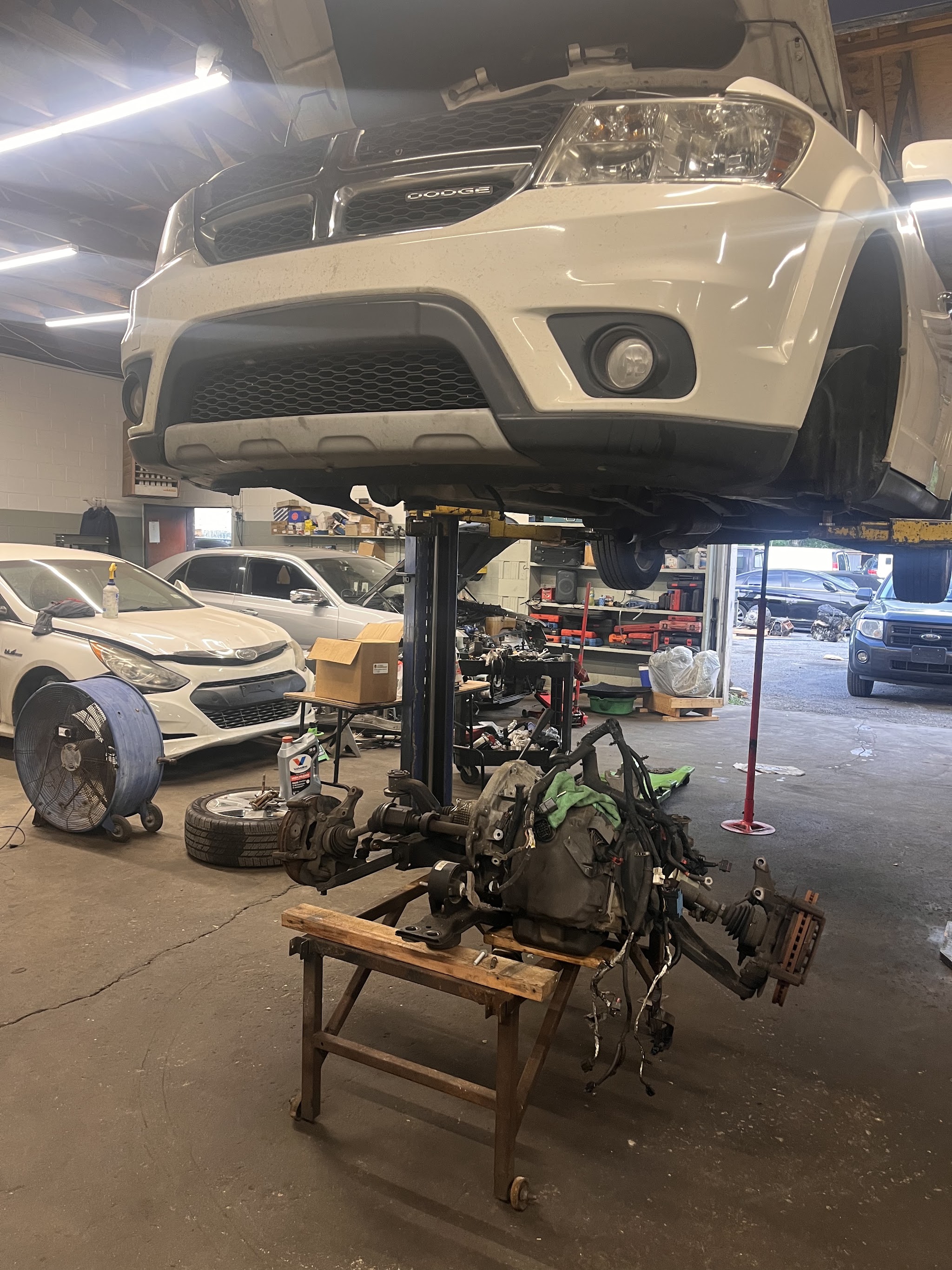 Our shop floor with an SUV on the lift and a drivetrain on a stand