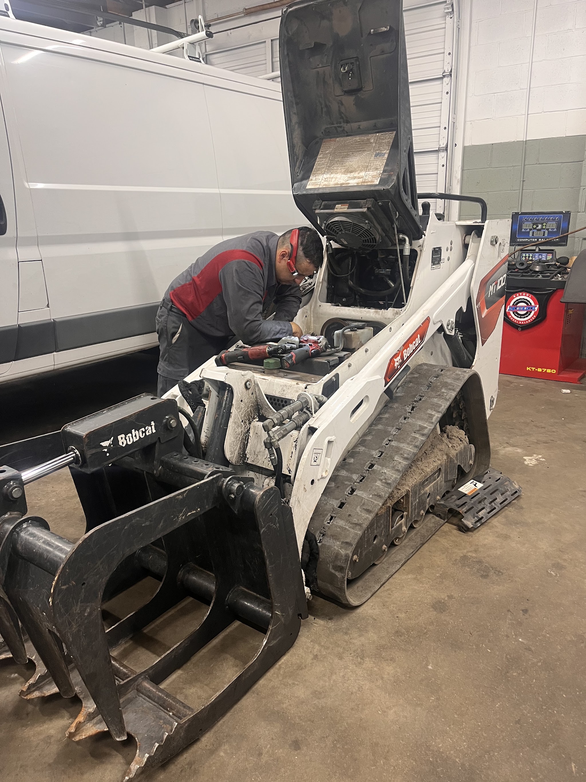 One of our mechanics working on a compact loader in the shop